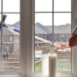 Tecahnician cleaning a large residential window in Niagara Falls – part of NLLC’s expert window cleaning services.