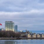 Canadian flag waving in front of the Toronto skyline and CN Tower, representing Ontario immigration news.