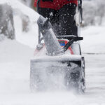 Snow removal in progress on a residential and commercial property, highlighting the difference between services and safety measures.
