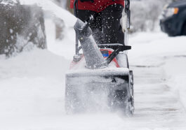 Snow removal in progress on a residential and commercial property, highlighting the difference between services and safety measures.