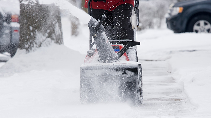 Snow removal in progress on a residential and commercial property, highlighting the difference between services and safety measures.